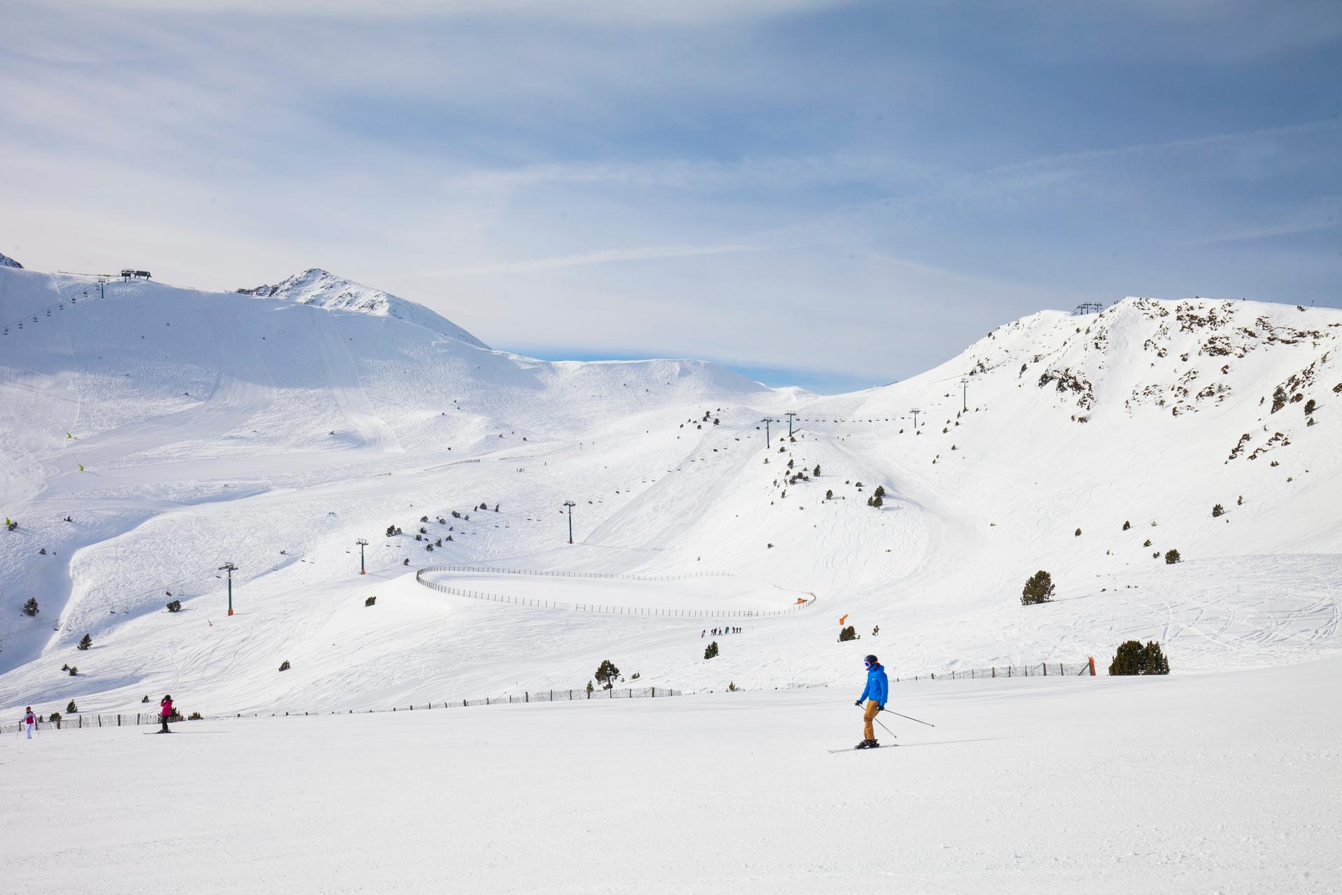 Skiier skiing down wide open slope in Soldeu Andorra